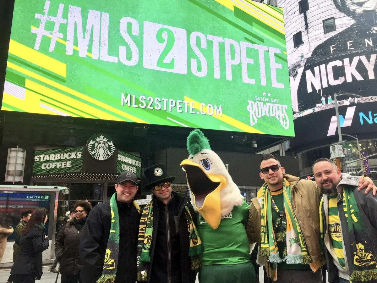 Rowdies fans and the club mascot in Times Square under the #MLS2StPete screen